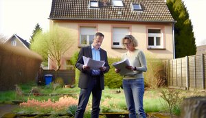 Familie steht vor geerbtem Einfamilienhaus und bespricht nächste Schritte