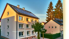 Modernes Wohnhaus mit Photovoltaikanlage auf dem Dach und frisch gedämmter Fassade im Sonnenlicht